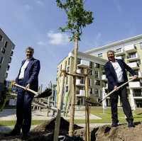 Ministerpräsident Dr. Markus Söder und Bauminister Christian Bernreiter pflanzen einen Baum in der neuen Wohnanlage für Staatsbedienstete in München